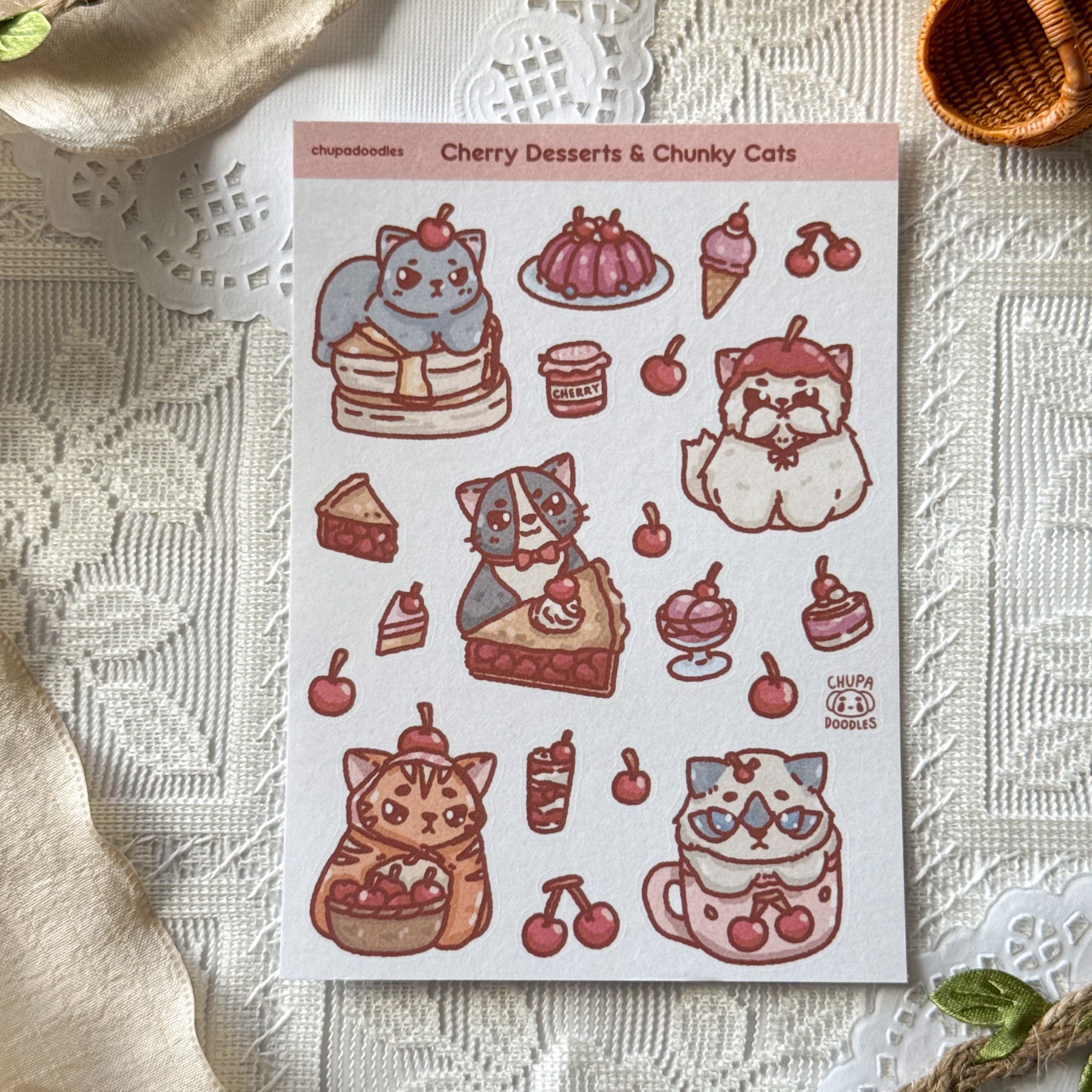 Sheet of stickers featuring cats and desserts on a textured surface